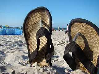 Die Rückseite von zwei großen Pinguinfiguren am Strand.